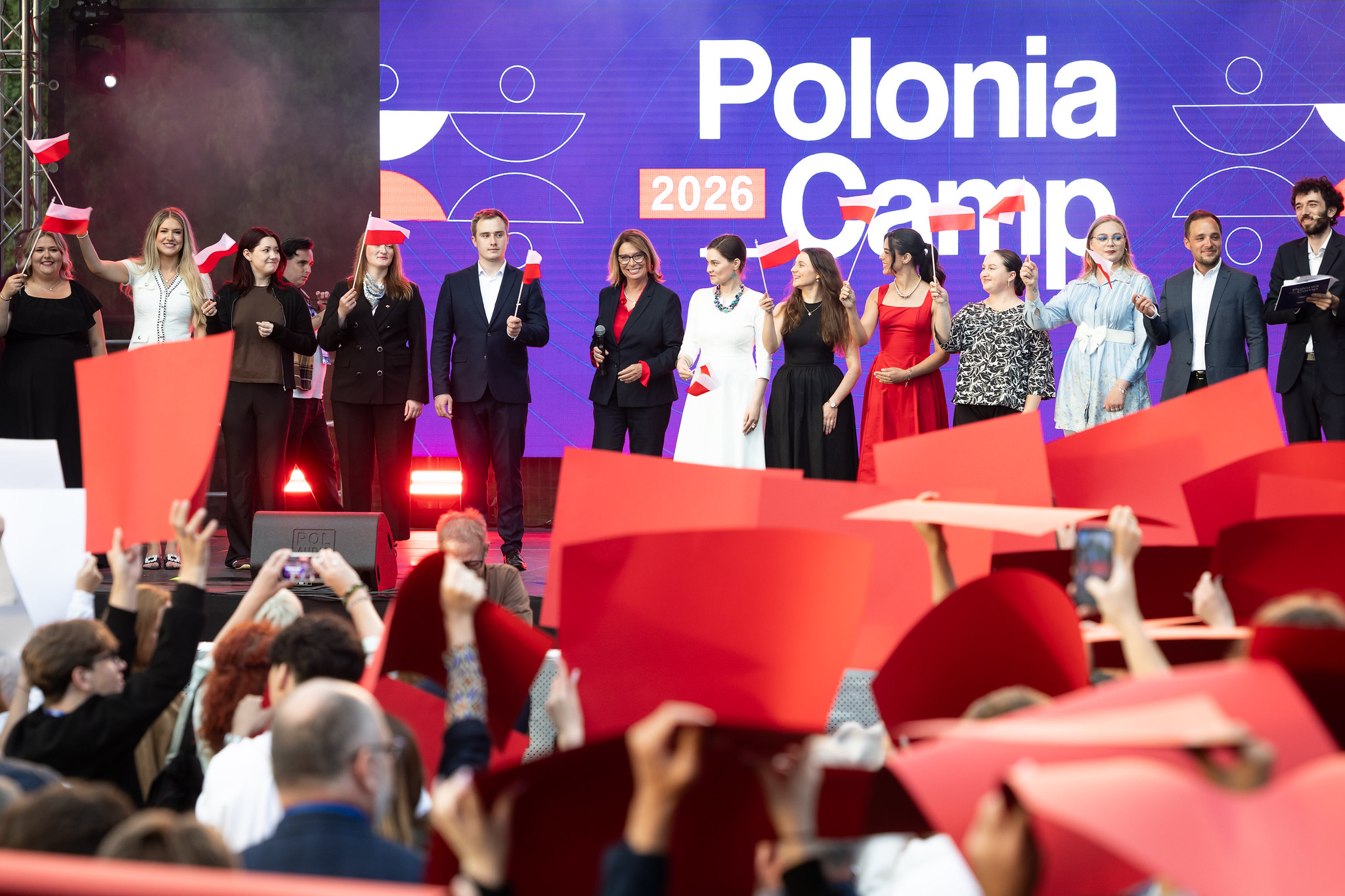 Uczestnicy inauguracji Polonia Camp 2026 na scenie z polskimi flagami